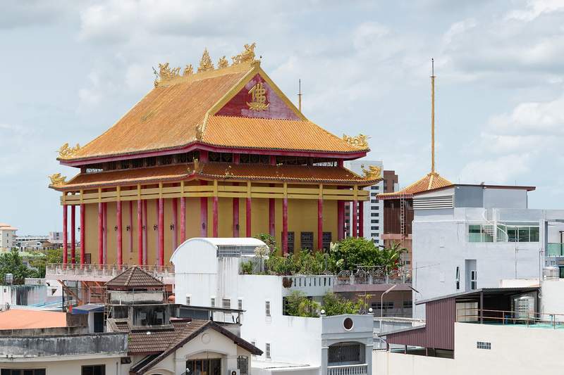 หลังคาสีทองแดงของวัดถาวรารามท่ามกลางอาคารในเมืองหาดใหญ่